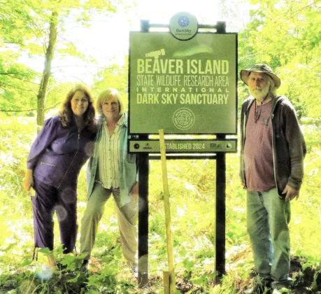 Sign raising crew...Members of the Beaver Island Dark Sky Project, Cynthia Johnson, Pam Grassmick, William Markey, pose with the newly raised official Sanctuary Sign.